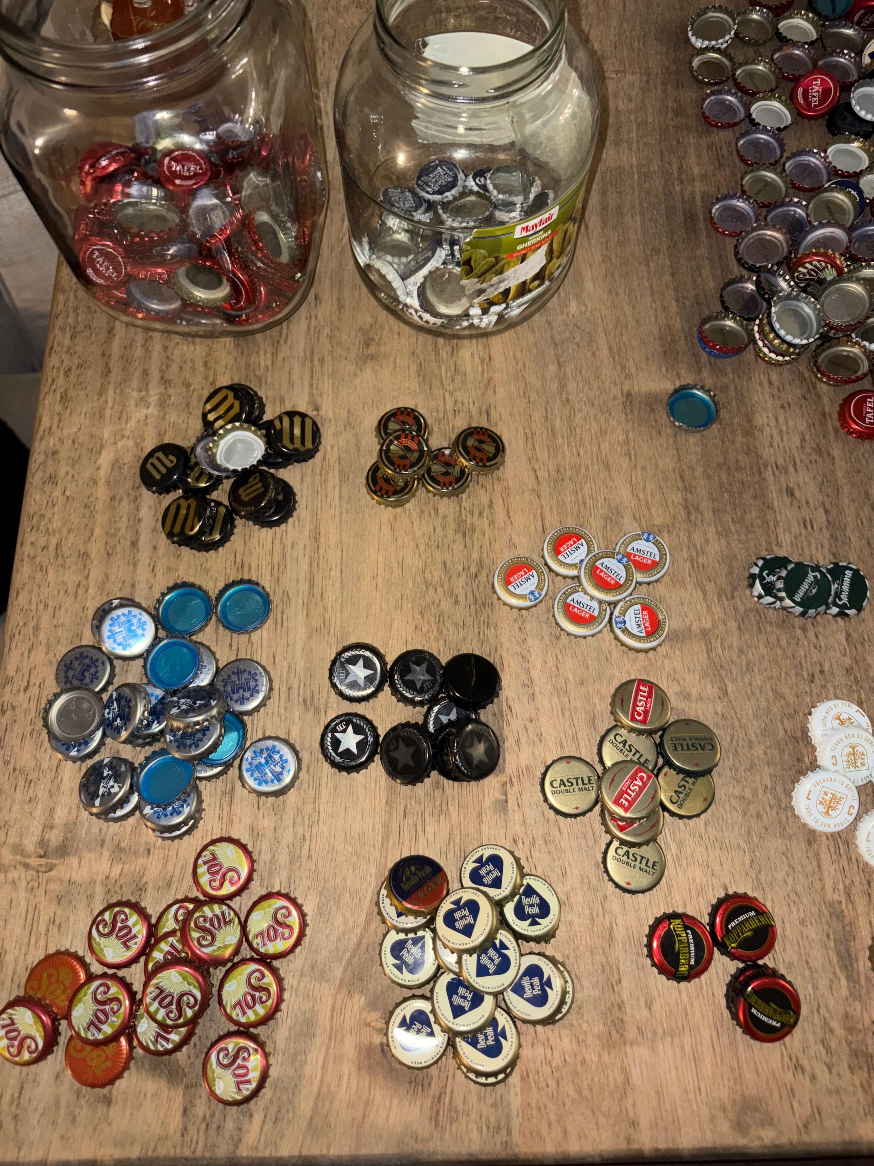 Jars of collected bottle tops, sorted before becoming YourTurn playing pieces.