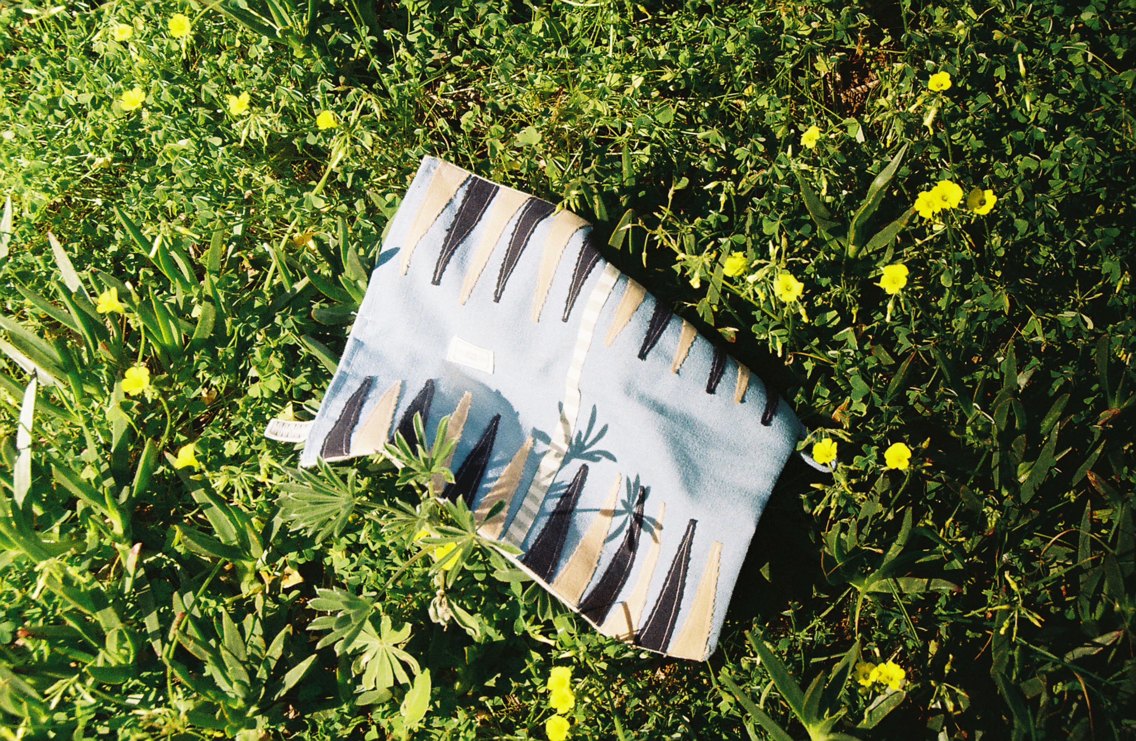 A YourTurn board laid out in the grass among wildflowers.