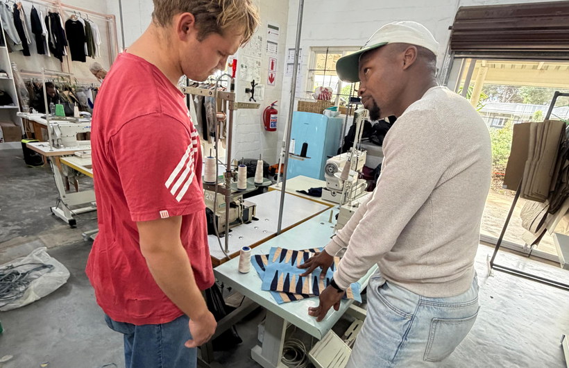 A YourTurn team member going over a board with a maker at the cutting table.